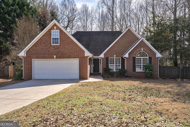 traditional-style house featuring driveway, brick siding, an attached garage, and fence