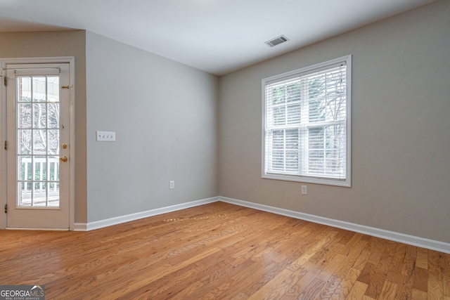 unfurnished room with light wood-type flooring, baseboards, and visible vents