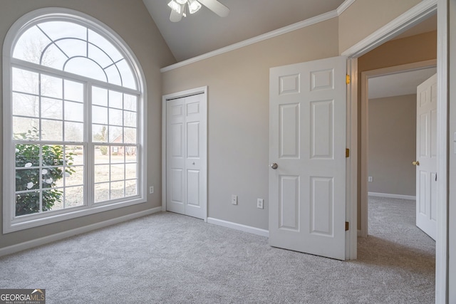 unfurnished bedroom featuring vaulted ceiling, a closet, baseboards, and light colored carpet