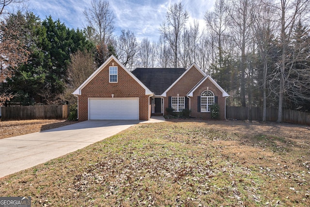 traditional-style house with an attached garage, brick siding, fence, concrete driveway, and a front yard