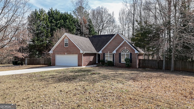 view of front of home featuring concrete driveway, brick siding, a front yard, and fence