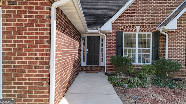 view of exterior entry with brick siding