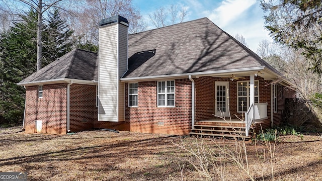 back of property featuring crawl space, brick siding, and a chimney