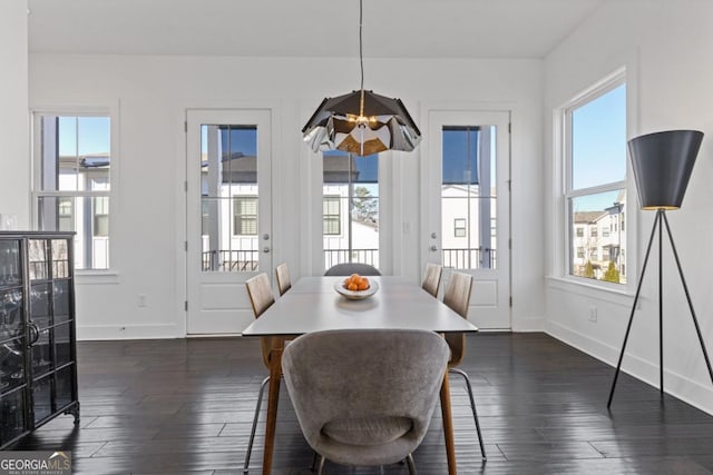 dining room with baseboards and dark wood-type flooring