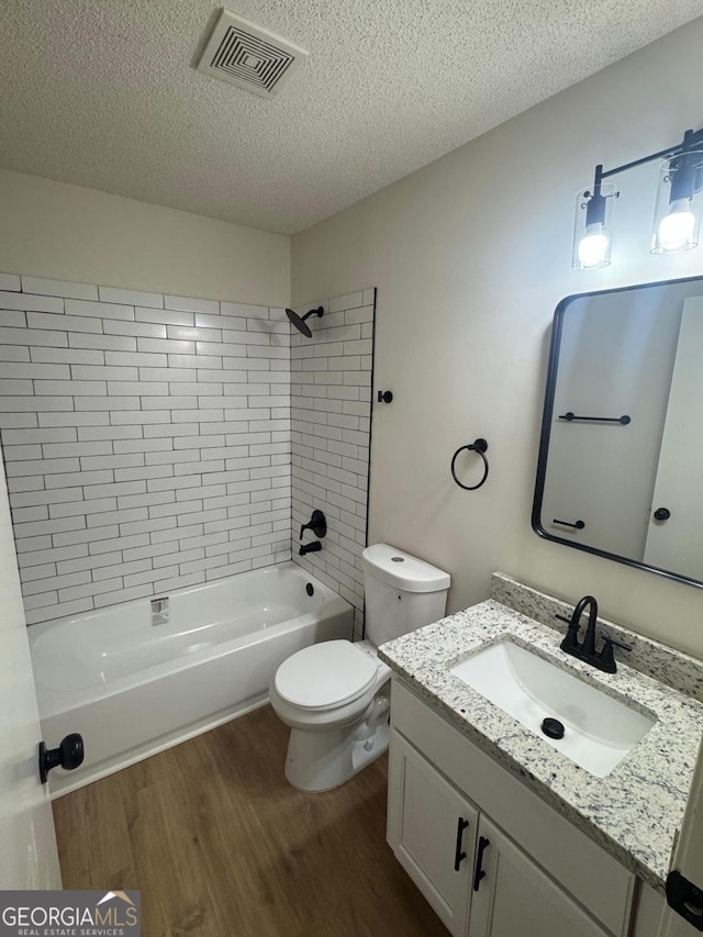 1753 Lee St, Decatur, GA 30035 - full bathroom with hardwood / wood-style floors, vanity, a textured ceiling, tiled shower / bath, and toilet