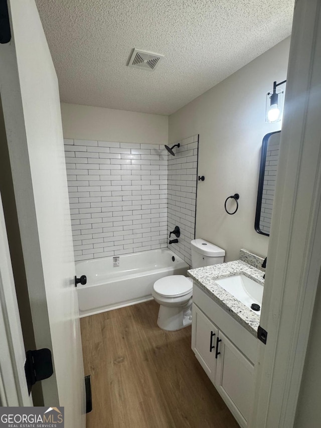 1753 Lee St, Decatur, GA 30035 - full bathroom featuring tiled shower / bath, toilet, a textured ceiling, hardwood / wood-style floors, and vanity