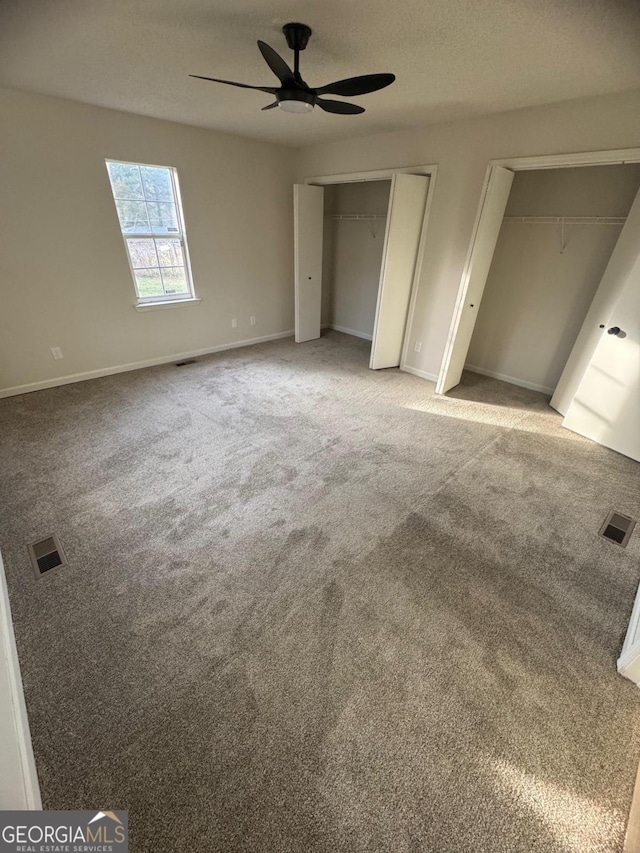 1753 Lee St, Decatur, GA 30035 - unfurnished bedroom featuring carpet floors, a textured ceiling, ceiling fan, and multiple closets