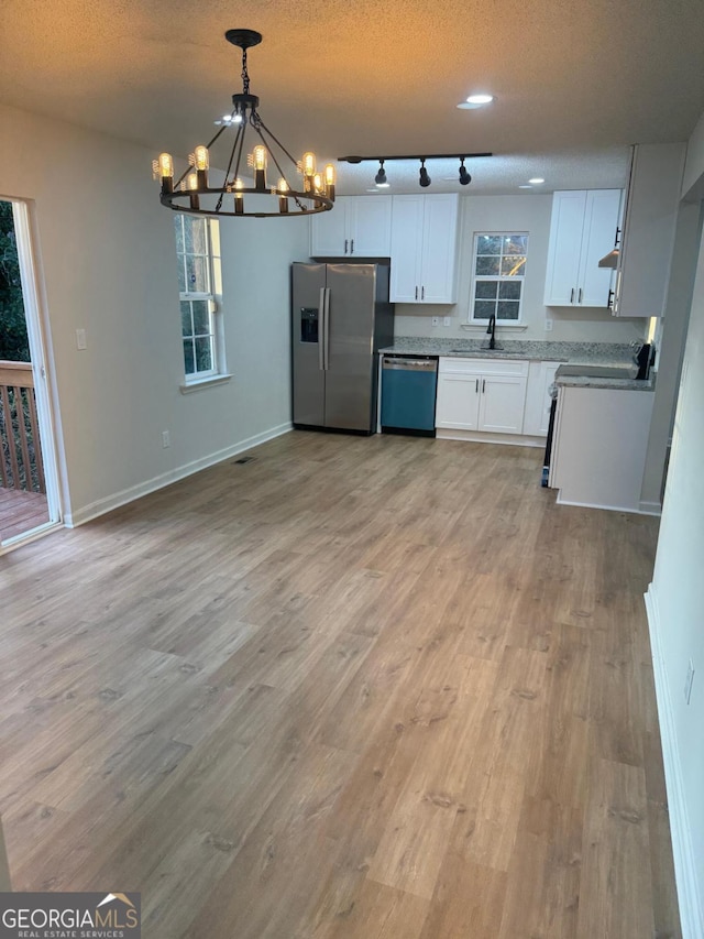 1753 Lee St, Decatur, GA 30035 - kitchen featuring appliances with stainless steel finishes, sink, pendant lighting, light hardwood / wood-style floors, and white cabinets