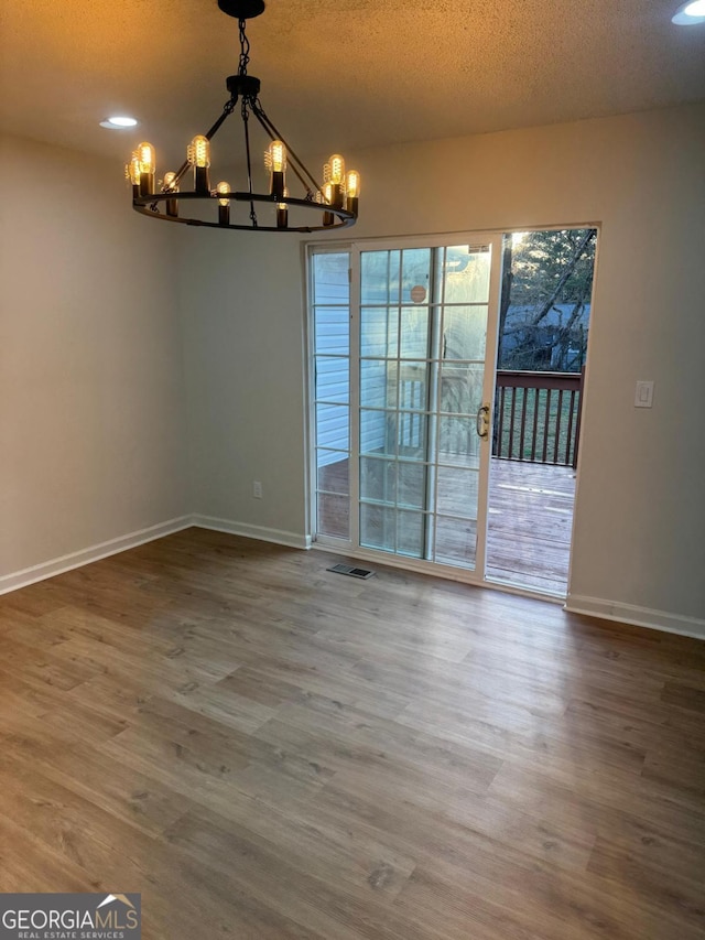 1753 Lee St, Decatur, GA 30035 - unfurnished dining area with a chandelier, wood-type flooring, and a textured ceiling