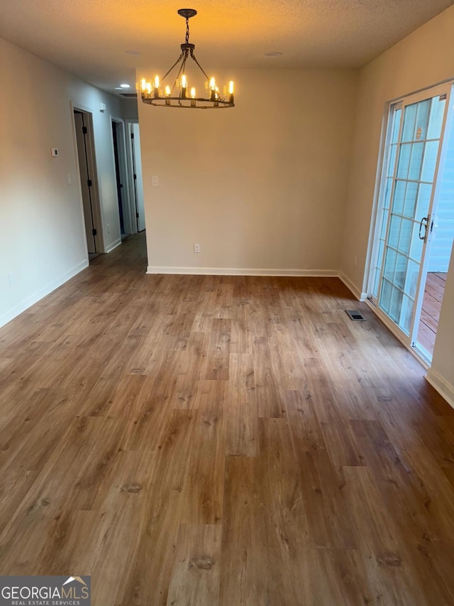 1753 Lee St, Decatur, GA 30035 - unfurnished dining area with an inviting chandelier, a textured ceiling, and hardwood / wood-style flooring