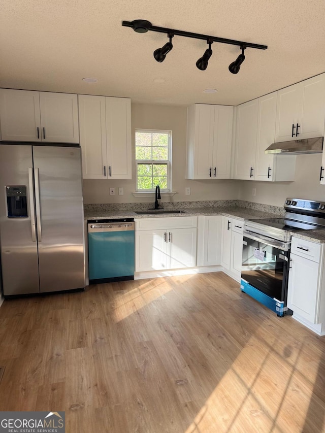 1753 Lee St, Decatur, GA 30035 - kitchen featuring sink, appliances with stainless steel finishes, white cabinets, and light hardwood / wood-style flooring