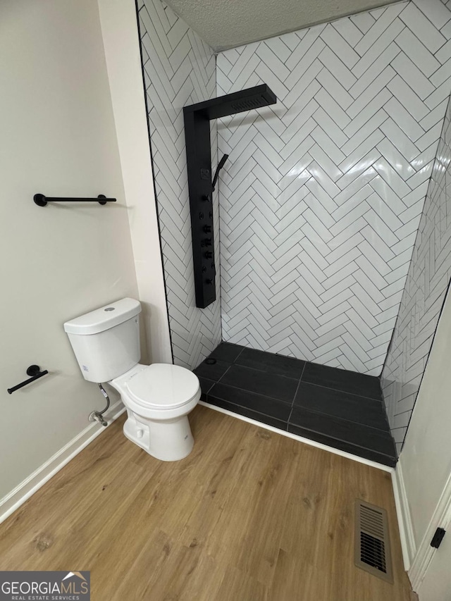 1753 Lee St, Decatur, GA 30035 - bathroom with toilet, tiled shower, and wood-type flooring