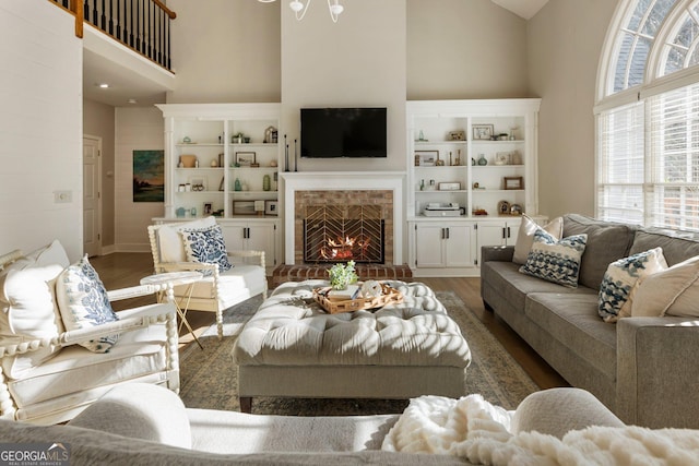 living room with dark wood-style floors, a fireplace, and a high ceiling