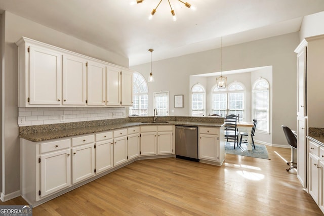 kitchen with light wood-style flooring, a sink, hanging light fixtures, and stainless steel dishwasher