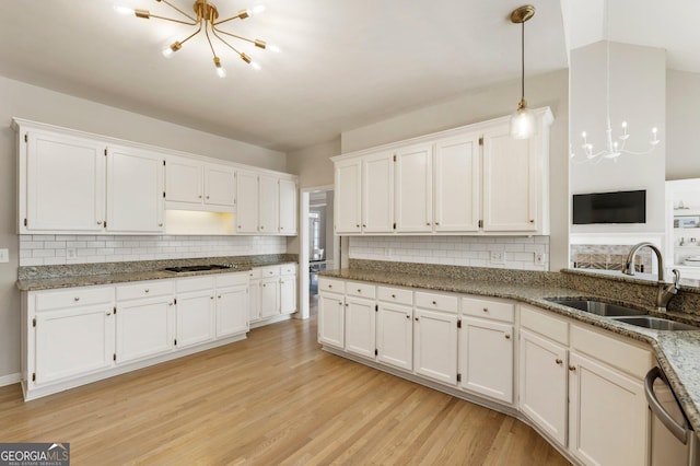 kitchen with white cabinets, a sink, and decorative light fixtures