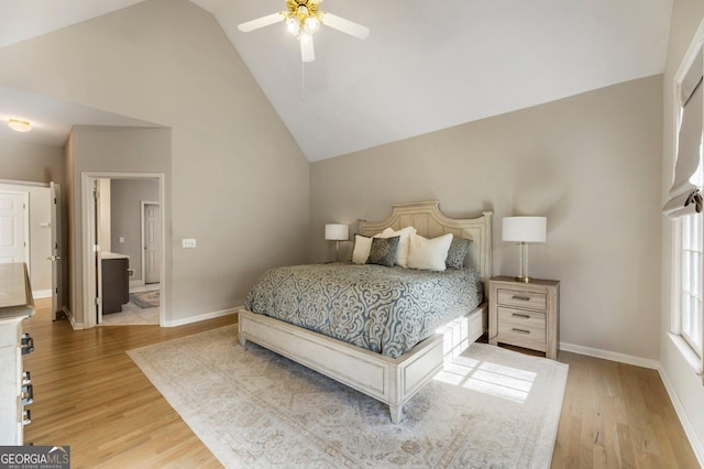 bedroom with light wood finished floors, baseboards, and high vaulted ceiling