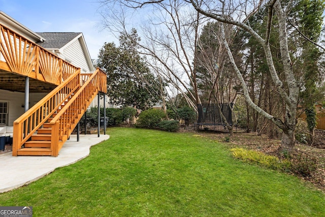 view of yard with a patio area, stairs, a trampoline, and a deck