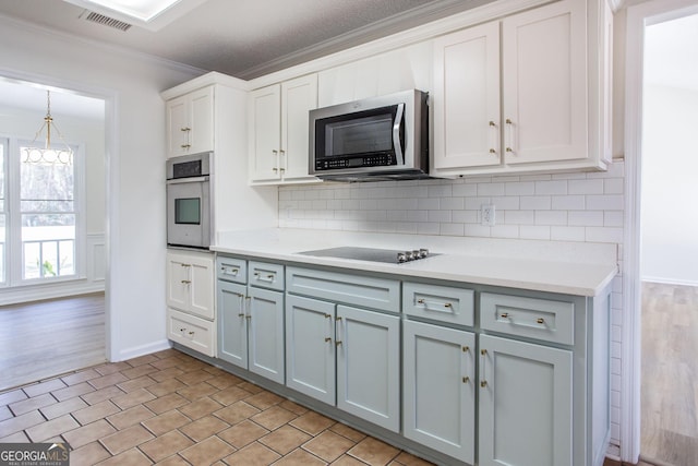 702 Hillmont Dr, Waycross, GA 31503 - kitchen with appliances with stainless steel finishes, crown molding, light countertops, and tasteful backsplash