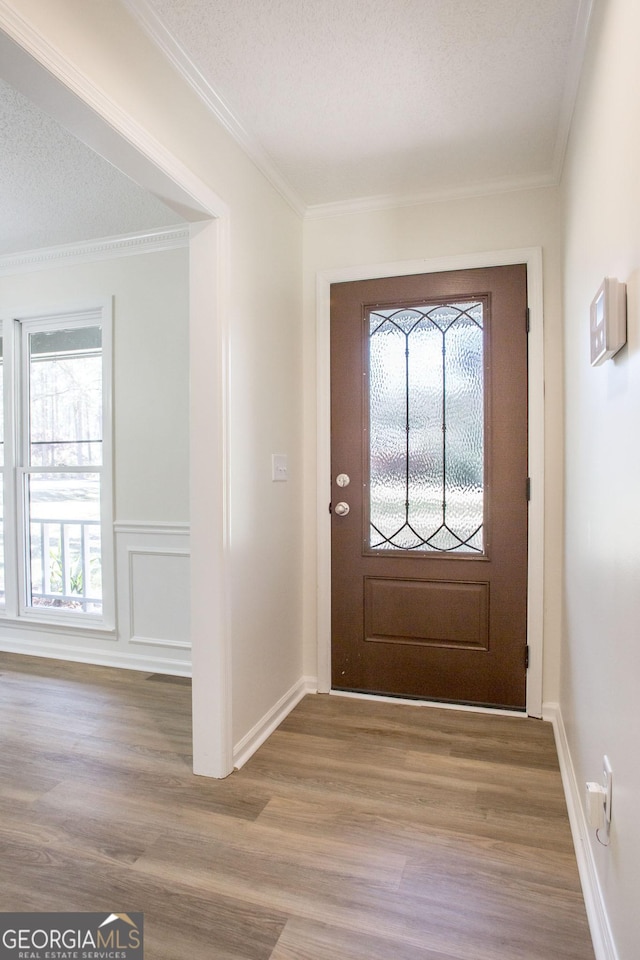 702 Hillmont Dr, Waycross, GA 31503 - foyer featuring light wood-type flooring, a textured ceiling, and crown molding