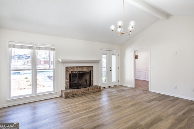 702 Hillmont Dr, Waycross, GA 31503 - unfurnished living room with beamed ceiling, wood finished floors, a chandelier, a brick fireplace, and high vaulted ceiling