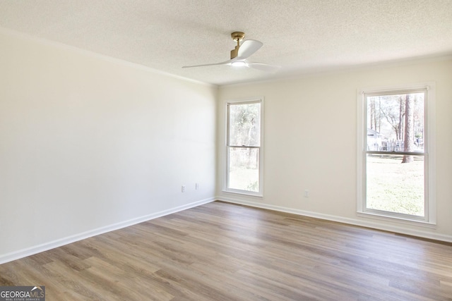 702 Hillmont Dr, Waycross, GA 31503 - unfurnished room featuring a textured ceiling, wood finished floors, plenty of natural light, and a ceiling fan
