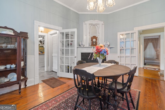 dining area featuring ornamental molding, a chandelier, and wood-type flooring