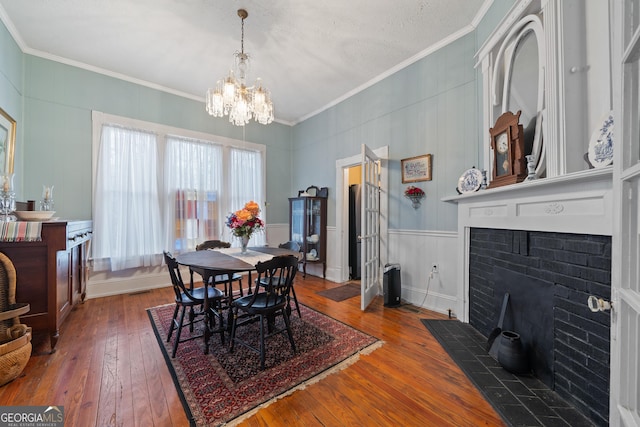 dining space featuring a notable chandelier, ornamental molding, and wood-type flooring