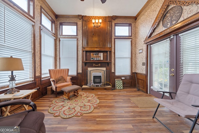 living room with hardwood / wood-style flooring, plenty of natural light, a large fireplace, and ornamental molding