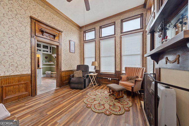 sitting room with ceiling fan, crown molding, and hardwood / wood-style floors