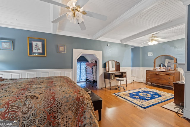 bedroom with beam ceiling, ceiling fan, wood-type flooring, and ornamental molding