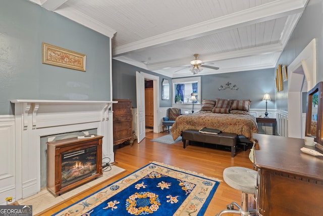 bedroom with light wood-type flooring, beamed ceiling, ornamental molding, and ceiling fan