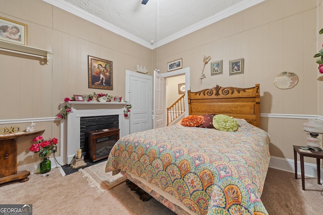 carpeted bedroom with ceiling fan, a textured ceiling, and ornamental molding