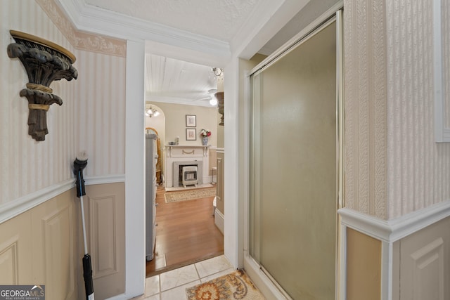 bathroom featuring an enclosed shower, tile patterned floors, ornamental molding, ceiling fan, and a textured ceiling