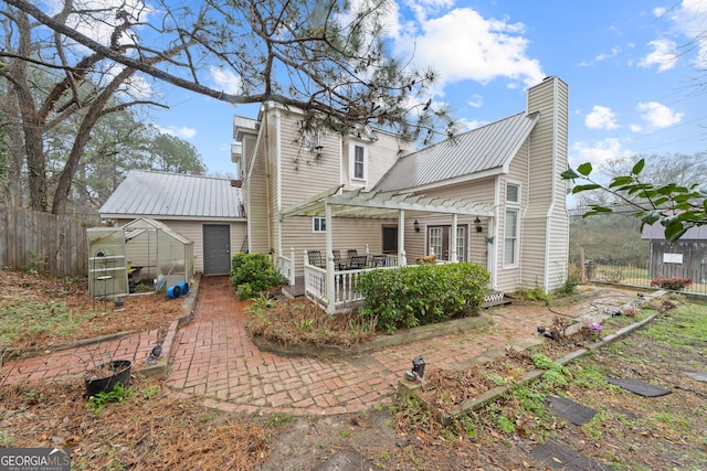 back of property with a pergola and an outdoor structure