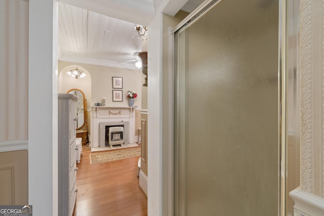 bathroom featuring hardwood / wood-style flooring, crown molding, and an enclosed shower