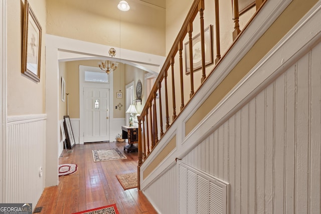 entryway with an inviting chandelier and wood-type flooring