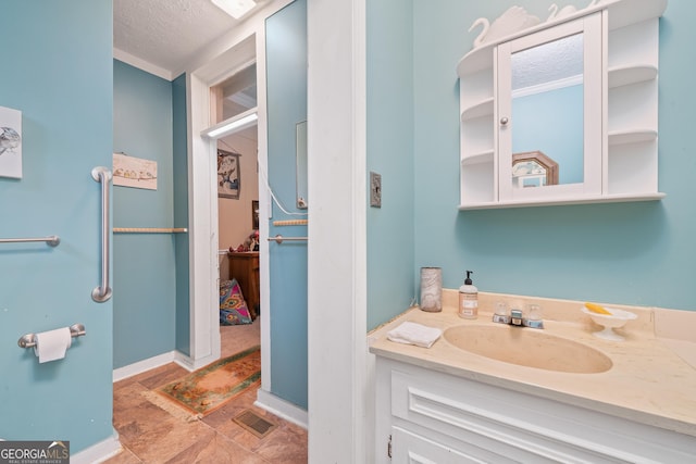 bathroom with a textured ceiling and vanity