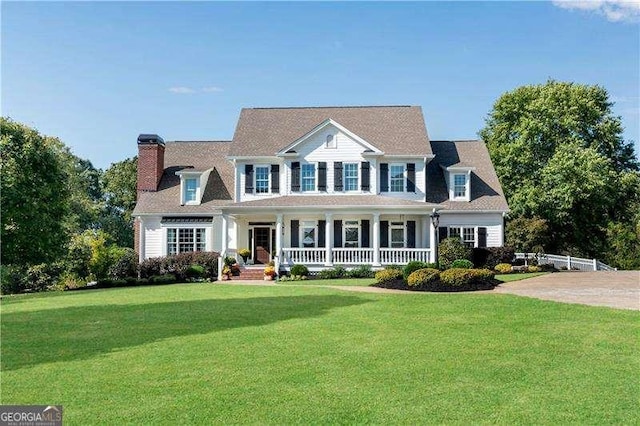 colonial inspired home featuring a front lawn and a porch