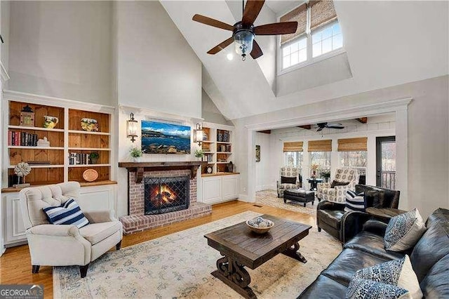 living room with ceiling fan, a wealth of natural light, and light hardwood / wood-style flooring