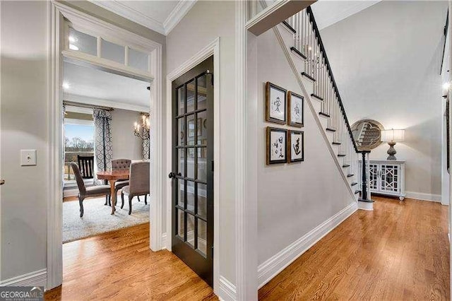 corridor with ornamental molding, an inviting chandelier, and wood-type flooring