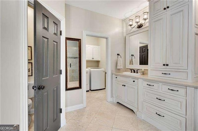 bathroom with tile patterned floors, toilet, vanity, and washing machine and clothes dryer