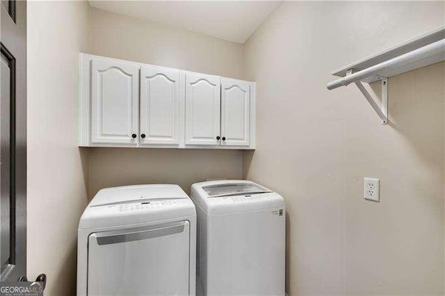 washroom featuring washer and dryer and cabinets