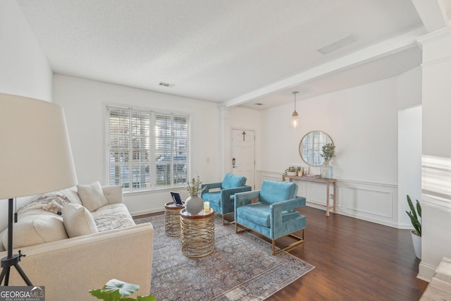 living room with a textured ceiling and dark hardwood / wood-style floors