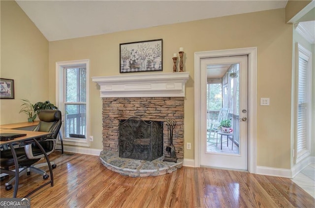 office space featuring a stone fireplace and wood-type flooring