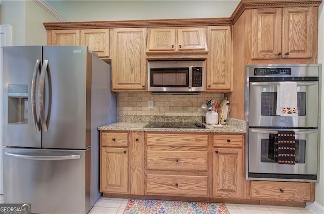 kitchen featuring decorative backsplash, appliances with stainless steel finishes, light tile patterned flooring, and light stone counters