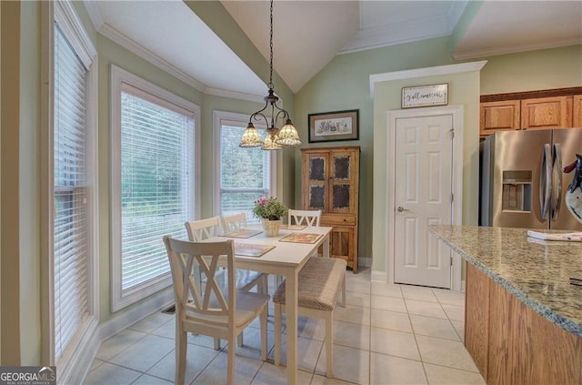 tiled dining room with ornamental molding and lofted ceiling