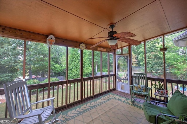 unfurnished sunroom with ceiling fan