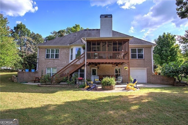 rear view of property featuring a lawn, a patio area, a garage, and a sunroom