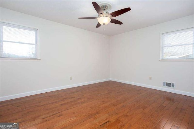 unfurnished room featuring ceiling fan, hardwood / wood-style flooring, and a wealth of natural light