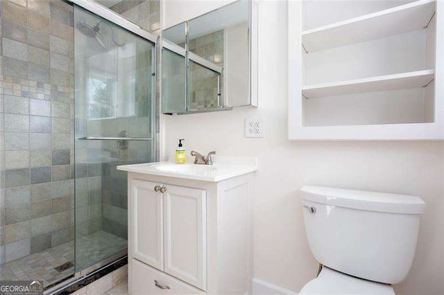 bathroom featuring vanity, toilet, and a shower with door